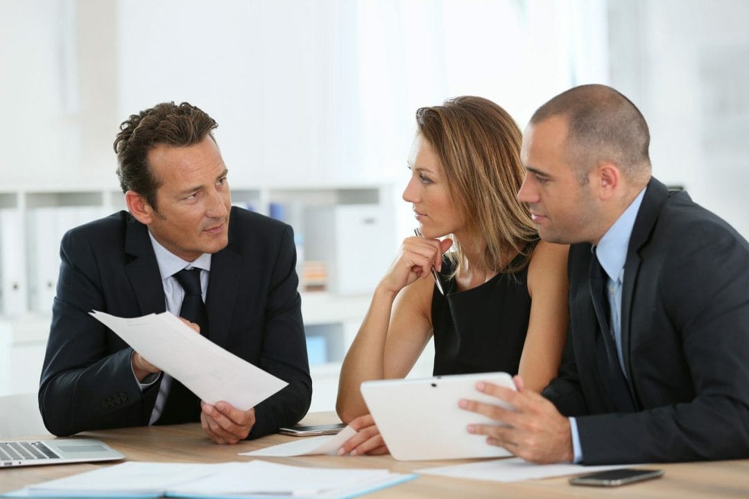 Three people talking on a table Three people talking on a table